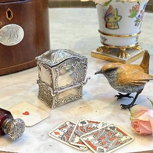 La vida no es cuestión de tener las cartas, sino de jugar bien una mala mano, dijo Wickham sosteniendo una caja de cartas de silla de manos de plata antigua y novedosa.