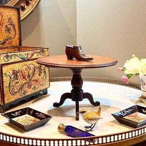 El conde compró una mesa de aprendizaje en miniatura antigua para la condesa, a quien le encantaban todas las miniaturas, excepto las de Cartier, por supuesto.