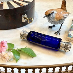The Marchesa said after one forgets what gown a woman wore the memory of her perfume lingers holding an Antique Blue Cut Glass Scent Bottle
