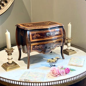A lady can never have enough admirers or Jewels the Countess said  filling her Antique Miniature Inlaid Mahogany Bombe Commode with Cartier