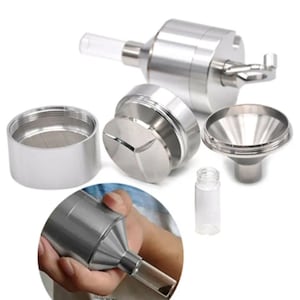 May include: A disassembled silver metal herb grinder with a clear glass tube and a small glass vial. The grinder has a multi-piece design, including a top, bottom, and a sifting chamber. The components are arranged on a white background.