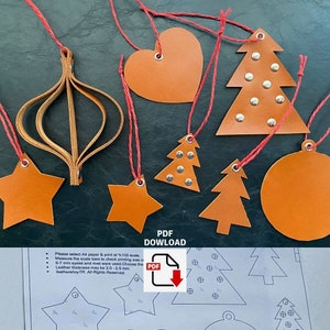 Peut inclure: Un ensemble de huit décorations de Noël en cuir marron avec un cordon rouge. Les décorations comprennent une étoile, un cœur, un cercle et quatre sapins de Noël. Les décorations sont ornées de rivets argentés. L'image comprend également une instruction de téléchargement PDF avec le texte "PDF DOWNLOAD".