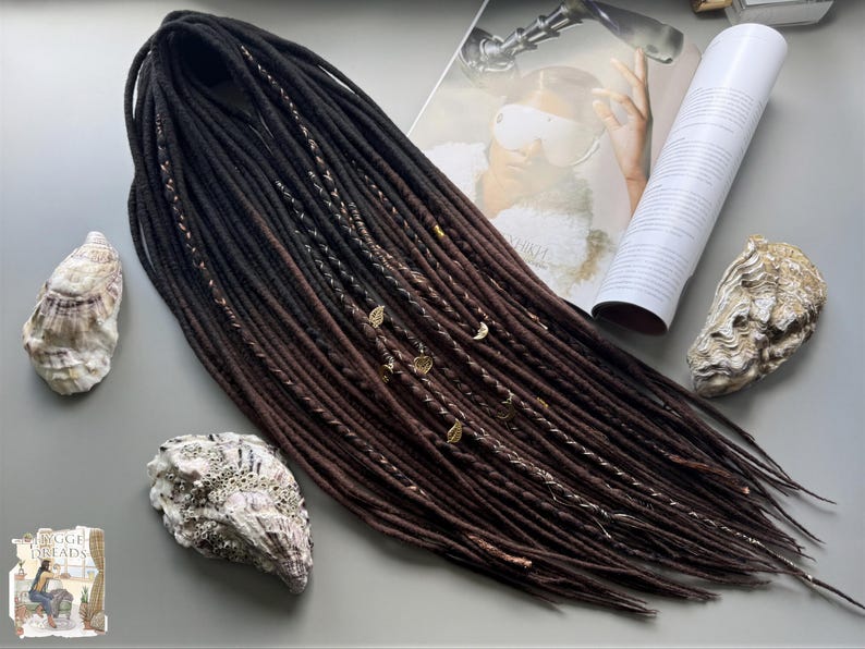 a collection of hair accessories, including a long braided hairstyle, seashells, and a magazine with a picture of a woman.