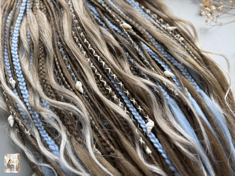 a close-up view of a collection of braided hair strands in various shades of brown and blonde, with some blue and white accents.