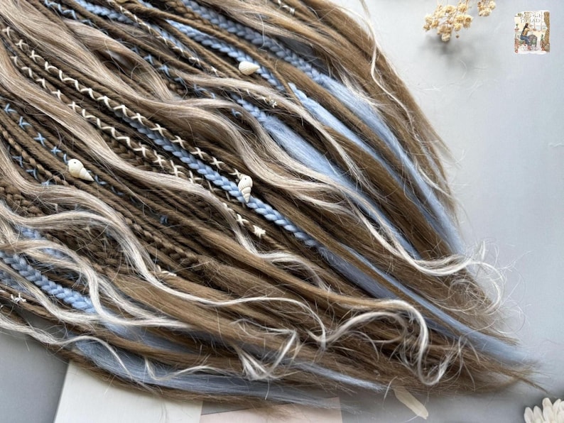a close-up view of a person's long, braided hairstyle with various colored braids and decorative elements such as beads and flowers.