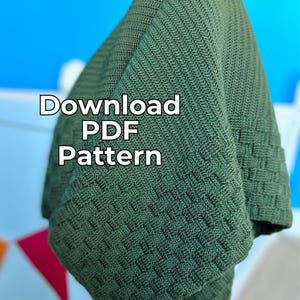 May include: Olive green knitted blanket with a textured basketweave pattern. The blanket is folded, revealing the intricate stitchwork. Text on the blanket reads "Download PDF Pattern".