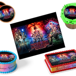 May include: An assortment of edible decorations featuring the "Stranger Things" theme. Includes two round coasters, a cupcake, a round cake with a rainbow border, and a rectangular cake with a red border. All items display the show's promotional artwork.