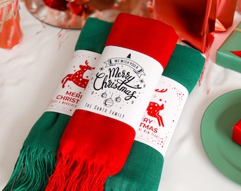May include: Two Christmas-themed scarves with white gift tags. The red scarf has a white tag with the text "We wish you a Merry Christmas The Gantu Family". The green scarf has a white tag with the text "Merry Christmas and a Happy New Year!"