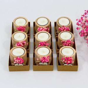 May include: Ten small wooden candle holders with pink flowers and a heart-shaped tag that says "Dawn & Julie" on each. The candle holders are arranged in two rows of five.
