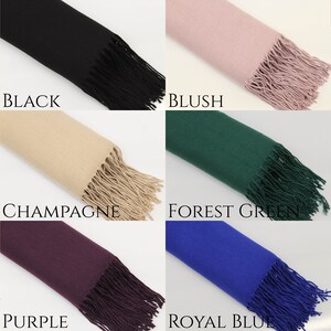 May include: A collection of 12 solid color scarves with fringe. The colors are baby blue, black, blush, burgundy, burnt orange, champagne, forest green, ivory, navy, purple, royal blue, and silver.