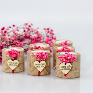 May include: Set of six small wooden candle holders with a heart-shaped tag that says "Dean & Julie 08.08.2024". Each holder is decorated with pink dried flowers.