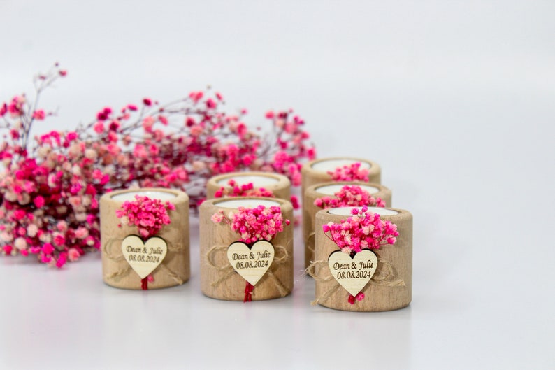 May include: Set of six small wooden candle holders with a heart-shaped tag that says "Dean & Julie 08.08.2024". Each holder is decorated with pink dried flowers.