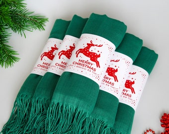 May include: Four green scarves with fringed edges are bundled together. Each scarf is wrapped with a white label featuring a red reindeer and the text "Merry Christmas and a Wonderful New Year".