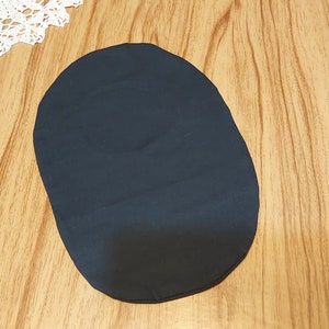 May include: A dark blue oval-shaped fabric patch.