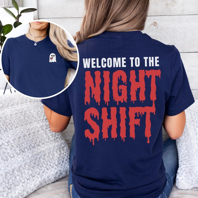 Peut inclure: Un t-shirt bleu marine avec un motif de fant&ocirc;me blanc sur la poche avant et le texte "WELCOME TO THE NIGHT SHIFT" en lettres rouges qui coulent au dos.