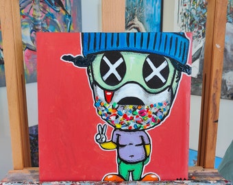 May include: A colorful painting of a cartoon character wearing a blue hat and a mask with a colorful pattern. The character has green skin and large, black eyes with white X's. The background is red.