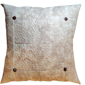 May include: A beige throw pillow with a quilted design and a decorative border. The pillow has four brown buttons on the front.