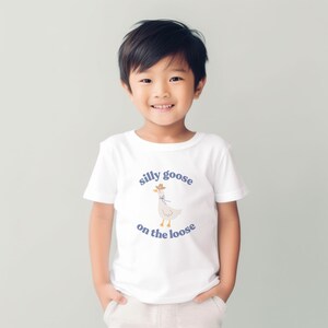 May include: A white t-shirt with a cartoon goose wearing a cowboy hat and the text "silly goose on the loose" in purple.