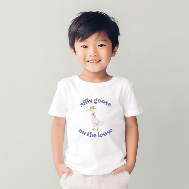 May include: A white t-shirt with a cartoon goose wearing a cowboy hat and the text "silly goose on the loose" in purple.
