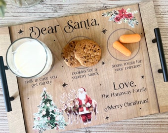 May include: Wooden tray with a Christmas theme. It has a glass of milk, cookies, carrots, and a Santa Claus illustration. The text on the tray reads "Dear Santa, milk in case you get thirsty, cookies for a yummy snack, some treats for your reindeer, Love, The Hanaway Family, Merry Christmas!"