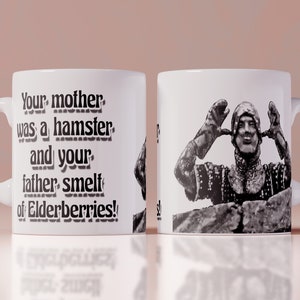 May include: White ceramic mug with a black and white image of a person in armor with the text "Your mother was a hamster and your father smelt of elderberries!" printed on the side.