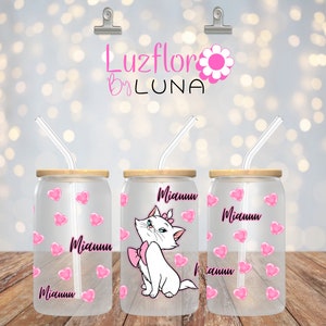 May include: Three clear glass canisters with bamboo lids and pink straws. Each canister has a different design. One has a pink heart pattern, another has a cartoon cat with a pink bow, and the last one has a pink heart pattern with the word "Miauuu" written on it.