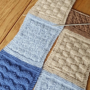 May include: A knitted scarf with different colored sections. The scarf is made with a variety of stitches, including a basket weave pattern, a cable stitch, and a seed stitch. The scarf is in shades of brown, beige, light blue, and dark blue.