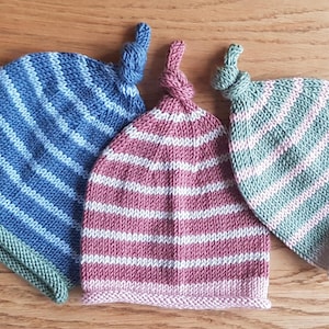 以下が含まれることがあります： 青と緑、ピンクと緑、赤と白のストライプのニット帽が3つあります
