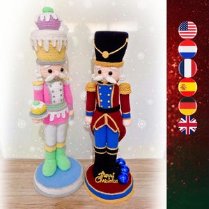May include: Two handmade crochet nutcrackers. One is pink and white with a cupcake hat, the other is red, blue, and black with a gold-trimmed hat. The red nutcracker has "Merry Christmas" on its base.