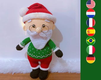 May include: A crocheted Santa Claus doll wearing a red hat with a white pom-pom, a green sweater with white trim, red trousers, and black boots. The doll features a white beard, a peach-colored face, and thin wire-rimmed glasses.
