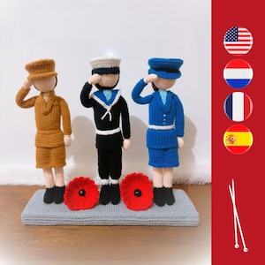 May include: Three knitted dolls wearing military uniforms, standing on a grey platform with red poppy flowers. The dolls are wearing a brown, blue, and black uniform. The dolls are saluting.