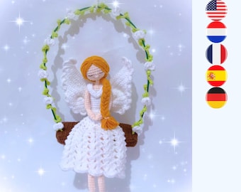 Peut inclure: Une poupée ange crochetée avec des cheveux en fil doré tressés, portant une robe et des ailes blanches. La poupée est assise sur une balançoire en bois marron suspendue par un cerceau vert orné de petites fleurs blanches au crochet.