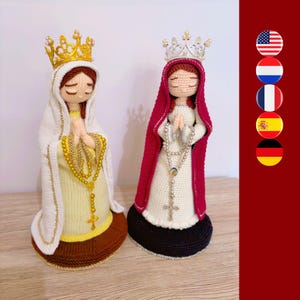 Può includere: Due statuette all'uncinetto raffiguranti figure con occhi chiusi e mani giunte in preghiera. La figura a sinistra indossa un velo bianco, una corona dorata e un abito giallo con un rosario dorato. La figura a destra indossa un velo rosa scuro, una corona argentata e un abito bianco con un rosario argentato.