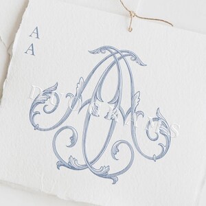 May include: A light blue monogram design featuring the intertwined letters "A" and "A" with ornate floral flourishes. The design is printed on a textured white paper, with the words "Instant download DUOGRAMS" at the bottom.