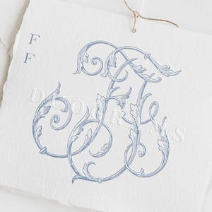May include: A blue and white monogram featuring the letter "F" in a decorative script font. The monogram is surrounded by a floral design. The text "DUOGRAMS" is printed below the monogram.
