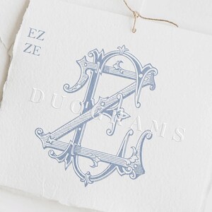 May include: A light blue monogram design on a white paper background. The monogram features the letters "EZ" and "A" in an ornate, stylized font. The words "DUOGRAMS" and "Instant download" are also visible.