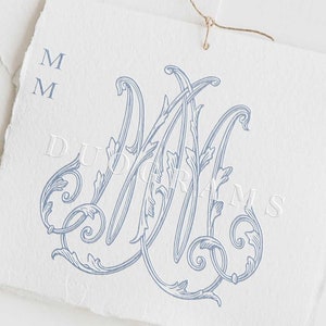 May include: A blue and white monogram with the letter "M" repeated twice, surrounded by ornate floral designs. The monogram is printed on a white textured paper background. The text "DUOGRAMS" is printed below the monogram.