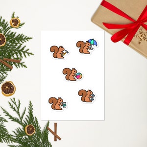 May include: Five sticker designs featuring a brown squirrel with different activities. The squirrel is holding a hammer, an umbrella, a beach ball, a dumbbell, and a cup of coffee.