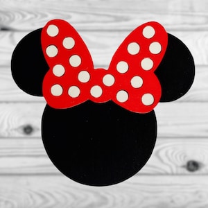 May include: Black and red felt cutout of a cartoon mouse head with white polka dots on the bow.