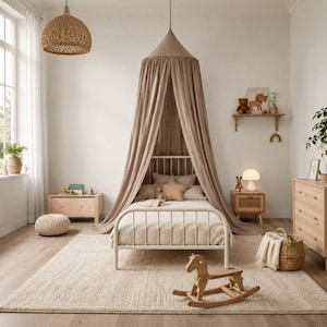 May include: A beige fabric bed canopy hangs from the ceiling over a white metal bed frame with a light-colored quilt and pillows. The room features a wooden rocking horse, a woven basket, a wooden dresser, and a light-colored area rug.