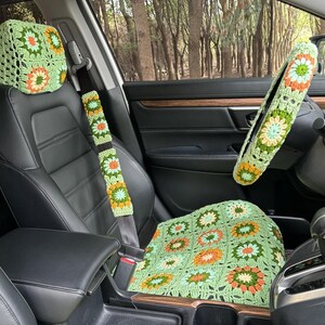 Pu&ograve; includere: Coprisedili per auto in crochet verde e arancio, tra cui una copertura per il poggiatesta, una copertura per il sedile e una copertura per il volante.