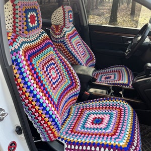 Könnte beinhalten: Ein Paar bunte Häkel-Autositzbezüge mit einem Granny-Square-Muster. Die Bezüge sind aus mehrfarbigem Garn gefertigt und weisen eine Vielzahl von Farben auf, darunter Rot, Blau, Grün, Gelb und Pink.