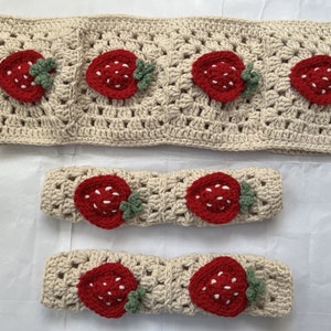 May include: Three crocheted headbands with strawberry designs. The headbands are beige with red and green strawberries.