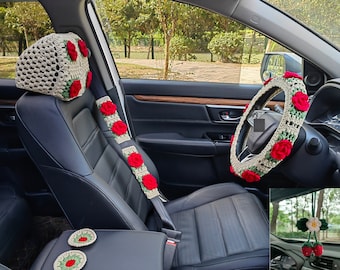 May include: A set of crocheted car accessories in a floral pattern with red and green accents. The set includes a headrest cover, a seatbelt cover, a steering wheel cover, and two small coasters.
