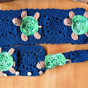 May include: A set of crocheted blue and green turtle-shaped dishcloths with a crocheted blue holder.