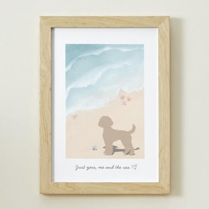 Peut inclure: Une impression encadrée représentant une scène de plage avec une silhouette de chien. L'œuvre d'art représente un rivage sablonneux, des vagues océaniques et des coquillages. Le texte "Just you, me and the sea" est en bas. Le cadre est en bois clair.