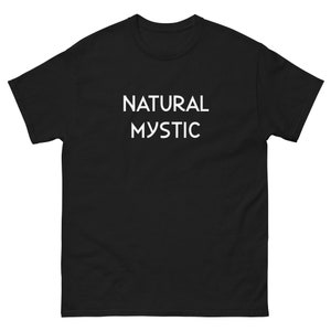K&ouml;nnte beinhalten: Schwarzes T-Shirt mit dem wei&szlig;en Text "NATURAL MYSTIC" auf der Vorderseite. Das Shirt hat einen Rundhalsausschnitt und kurze &Auml;rmel. Der Stoff scheint eine schwere Baumwollmischung zu sein.