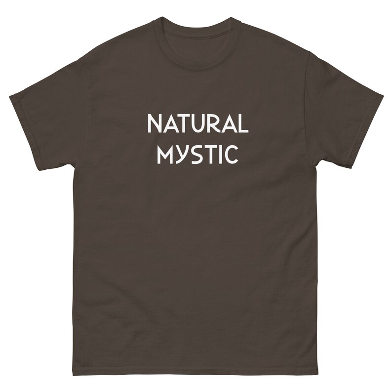 K&ouml;nnte beinhalten: Dunkelbraunes T-Shirt mit dem wei&szlig;en Schriftzug "NATURAL MYSTIC". Das T-Shirt hat kurze &Auml;rmel und einen Rundhalsausschnitt.