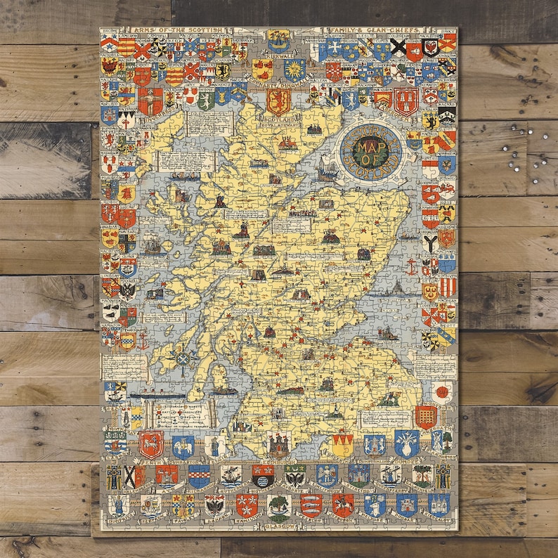 May include: A vintage map of Scotland, featuring a detailed illustration of the country's geography. The map is surrounded by colorful heraldic crests and the text "Map of Scotland". The puzzle is displayed on a wooden surface.