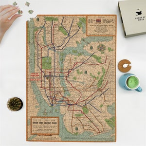 May include: A completed jigsaw puzzle depicting a vintage map of the New York City subway system, with red, blue, and orange lines. The puzzle is partially assembled, with a hand placing the final pieces. The text "UNION DIME SAVINGS BANK" is visible.